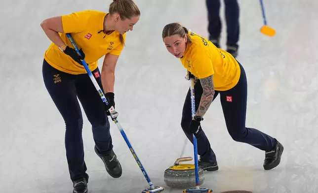 Sweden's Sara McManus, right, and Sofia Scharback compete, during a women's curling semifinal match against at the 2026 Winter Olympics, in Cortina d'Ampezzo, Italy, Friday, Feb. 20, 2026. (AP Photo/Fatima Shbair)