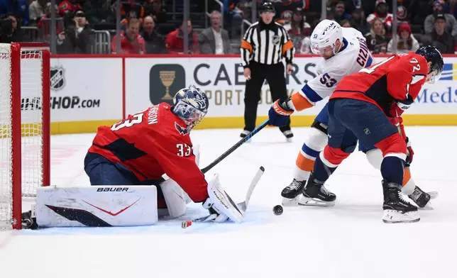 New York Islanders center Casey Cizikas (53) battles for the puck against Washington Capitals goaltender Clay Stevenson (33) and left wing Anthony Beauvillier (72) during the first period of an NHL hockey game, Monday, Feb. 2, 2026, in Washington. (AP Photo/Nick Wass)