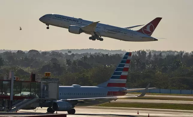 A Turkish Airlines plane takes off alongside an American Airlines plane at Jose Marti International Airport in Havana, Cuba, Monday, Feb. 9, 2026. (AP Photo/Ramon Espinosa)
