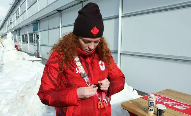 Kailey Allan, who is competing for Canada in the inaugural women's doubles luge looks at her favorite pins, at the Cortina Olympic Village, during the 2026 Winter Olympics, in Cortina d'Ampezzo, Italy, Thursday Feb. 5, 2026. (AP Photo/Jennifer McDermott)