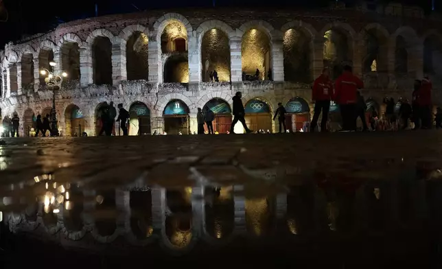 People arrive at the Verona Arena for the closing ceremony of the 2026 Winter Olympics, in Verona, Italy, Sunday, Feb. 22, 2026. (AP Photo/Francisco Seco)