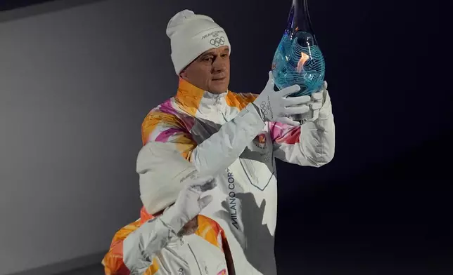 The Olympic flame is carried during the closing ceremony of the 2026 Winter Olympics, in Verona, Italy, Sunday, Feb. 22, 2026. (AP Photo/Ashley Landis)