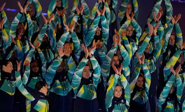 Olympic volunteers perform during the closing ceremony of the 2026 Winter Olympics, in Verona, Italy, Sunday, Feb. 22, 2026. (AP Photo/Ashley Landis)