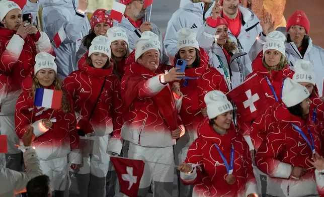Swiss athletes take a selfie during the closing ceremony of the 2026 Winter Olympics, in Verona, Italy, Sunday, Feb. 22, 2026. (AP Photo/Ashley Landis)