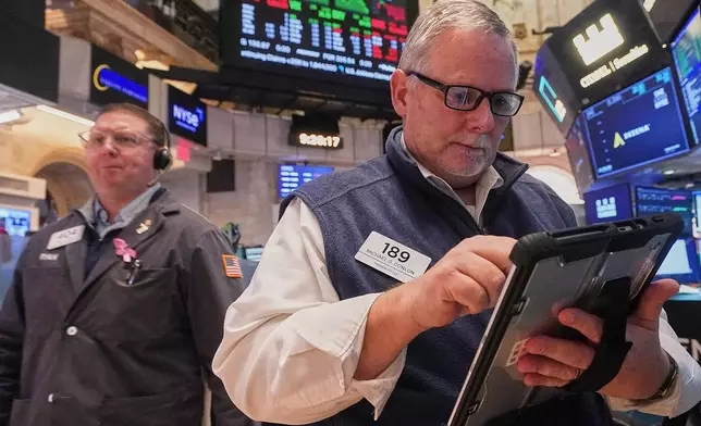 Trader Michael Conlon, right, works on the floor of the New York Stock Exchange, Thursday, Feb. 5, 2026. (AP Photo/Richard Drew)