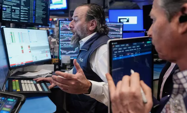Specialist Michael Pistillo, left, and trader Robert Charmak work on the floor of the New York Stock Exchange, Friday, Feb. 6, 2026. (AP Photo/Richard Drew)