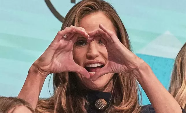 Once Upon a Farm co-Founder Jennifer Garner makes a heart on the New York Stock Exchange podium prior to ringing the opening bell for her company's IPO, Friday, Feb. 6, 2026. (AP Photo/Richard Drew)