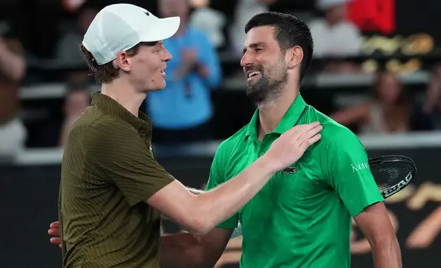 Novak Djokovic, right, of Serbia is congratulated by Jannik Sinner, left, of Italy following their semifinal match at the Australian Open tennis championship in Melbourne, Australia, early Saturday, Jan. 31, 2026. (AP Photo/Aaron Favila)