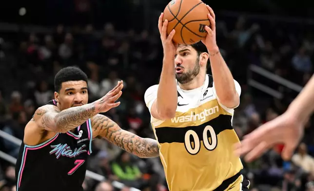 Washington Wizards forward Tristan Vukcevic (00) races to the basket against Miami Heat center Kel'el Ware during the first half of an NBA basketball game, Sunday, Feb. 8, 2026, in Washington. (AP Photo/John McDonnell)