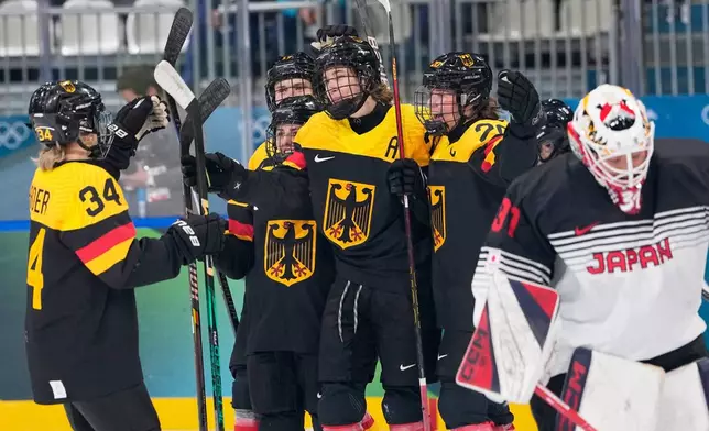 Germany's Laura Kluge, center, celebrates with teammates after scoring her sides fifth goal during a preliminary round match of women's ice hockey between Germany and Japan at the 2026 Winter Olympics, in Milan, Italy, Saturday, Feb. 7, 2026. (AP Photo/Petr David Josek)