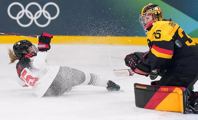 Japan's Rui Ukita, left, slides past Germany's Sandra Abstreiter during a preliminary round match of women's ice hockey between Germany and Japan at the 2026 Winter Olympics, in Milan, Italy, Saturday, Feb. 7, 2026. (AP Photo/Petr David Josek)