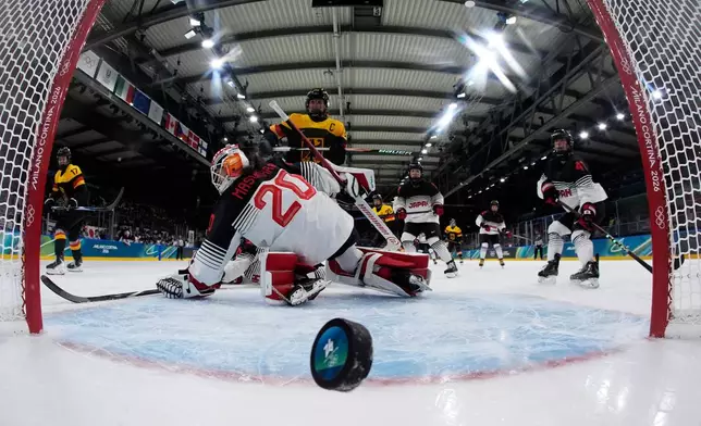 Germany's Emily Nix, left, scores her side's third goal during a preliminary round match of women's ice hockey between Germany and Japan at the 2026 Winter Olympics, in Milan, Italy, Saturday, Feb. 7, 2026. (AP Photo/Darko Bandic, Pool)