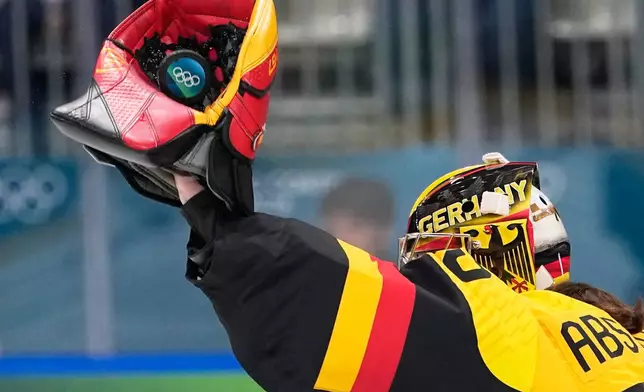 Germany's Sandra Abstreiter catches the puck during a preliminary round match of women's ice hockey between Germany and Japan at the 2026 Winter Olympics, in Milan, Italy, Saturday, Feb. 7, 2026. (AP Photo/Petr David Josek)