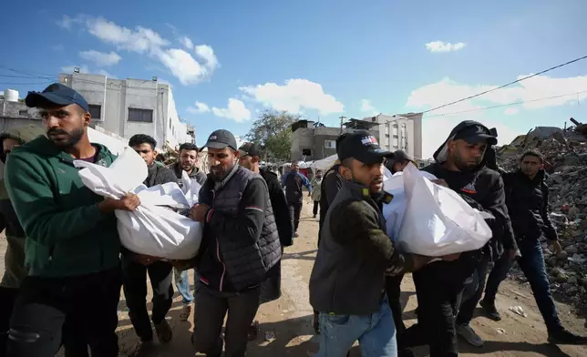 Mourners carry the bodies of two members of Hamas, Muhammad Abu Jabal, and Fadl Al-Burdini who were killed in an Israeli military strike, at Shifa Hospital in Gaza City Thursday, Feb. 26, 2026. (AP Photo/Jehad Alshrafi)