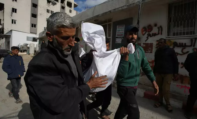 Mourners carry the bodies of two members of Hamas, Muhammad Abu Jabal, and Fadl Al-Burdini who were killed in an Israeli military strike, at Shifa Hospital in Gaza City Thursday, Feb. 26, 2026. (AP Photo/Jehad Alshrafi)