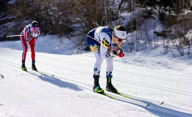 Ebba Andersson, of Sweden, leads Heidi Weng, of Norway, during the cross country skiing women's 50km mass start classic at the 2026 Winter Olympics, in Tesero, Italy, Sunday, Feb. 22, 2026. (AP Photo/Evgeniy Maloletka)