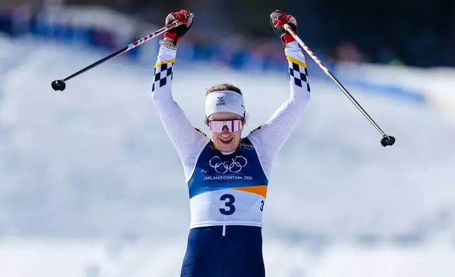 Ebba Andersson, of Sweden, crosses the finish line to win the gold medal in the cross country skiing women's 50km mass start classic at the 2026 Winter Olympics, in Tesero, Italy, Sunday, Feb. 22, 2026. (AP Photo/Matthias Schrader)