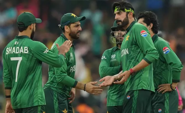 Pakistan's Usman Tariq, right , celebrates with captain Salman Ali Agha, centre, the wicket of Namibia's Ruben Trumpelmann during the T20 World Cup cricket match between Namibia and Pakistan in Colombo, Sri Lanka, Wednesday, Feb. 18, 2026. (AP Photo/Eranga Jayawardena)