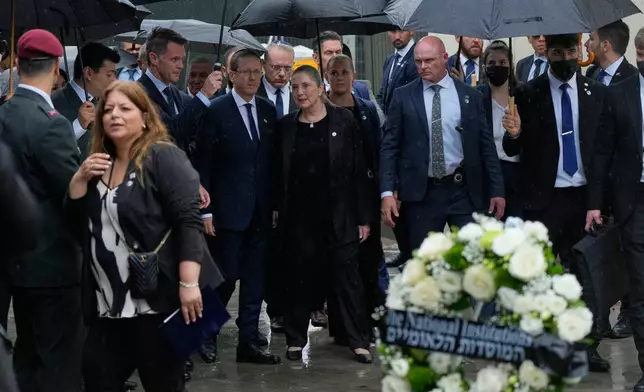 Israel's President Isaac Herzog, center left, and his wife Michal Herzog, center right, arrive at Bondi Beach for a memorial of the Dec. 2025 shooting victims, in Sydney, Monday, Feb. 9, 2026. (AP Photo/Rick Rycroft)