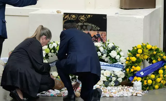 Israel's President Isaac Herzog, center, and his wife Michal Herzog, left, offer prayers at Bondi Beach where the Dec. 2025 shooting took place, in Sydney, Monday, Feb. 9, 2026. (AP Photo/Rick Rycroft)