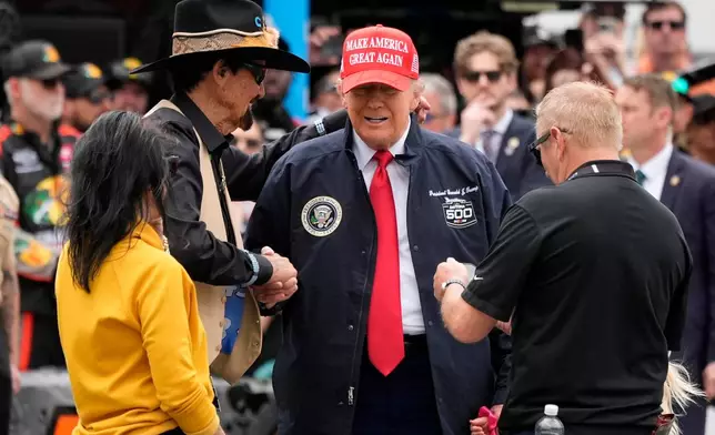FILE - President Donald Trump, second right, shakes hands with NASCAR Hall of Fame driver Richard Petty at the NASCAR Daytona 500 auto race at Daytona International Speedway, Feb. 16, 2025, in Daytona Beach, Fla. (AP Photo/John Raoux, File)