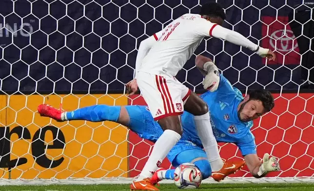 FC Dallas goalkeeper Michael Collodi, bottom, defends the goal against Toronto FC forward Derrick Etienne Jr., top, during the first half of an MLS soccer match in Frisco, Texas, Saturday, Feb. 21, 2026. (AP Photo/LM Otero)