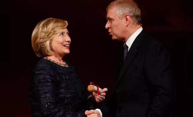 FILE - Britain's Prince Andrew, right, talks to former U.S. Secretary of State Hillary Clinton, left, as she is presented with the Chatham House prize, a scroll signed by Queen Elizabeth II, Patron of the institute, during the Chatham House Prize award ceremony in central London, Friday, Oct. 11, 2013. (AP Photo/Lefteris Pitarakis, File)