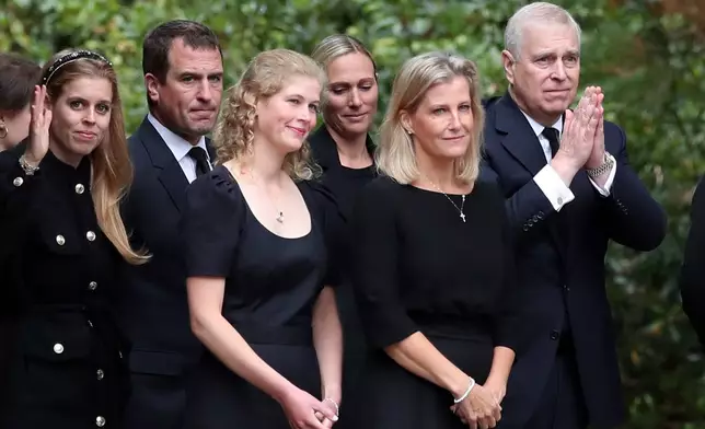 FILE - Prince Andrew, right, gestures to the public after looking at the floral tributes for Queen Elizabeth II, as others look on, outside the gates of Balmoral Castle in Aberdeenshire, Scotland Saturday, Sept. 10, 2022. (AP Photo/Scott Heppell, File)