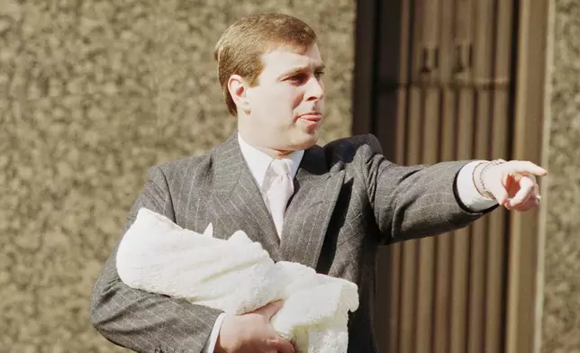 FILE - The Duke of York holds week-old Princess Eugenie Victoria Helena outside Portland Hospital in London, March 30, 1990. (AP Photo/Peter Kemp, File)