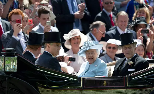 FILE - Britain's Queen Elizabeth II, centre, with Prince Philip, right, Prince Andrew, second right and Prince Harry, arrive by carriage, on the first day of the Royal Ascot horse racing meeting at Ascot, England, Tuesday, June 17, 2014. (AP Photo/Alastair Grant, File)
