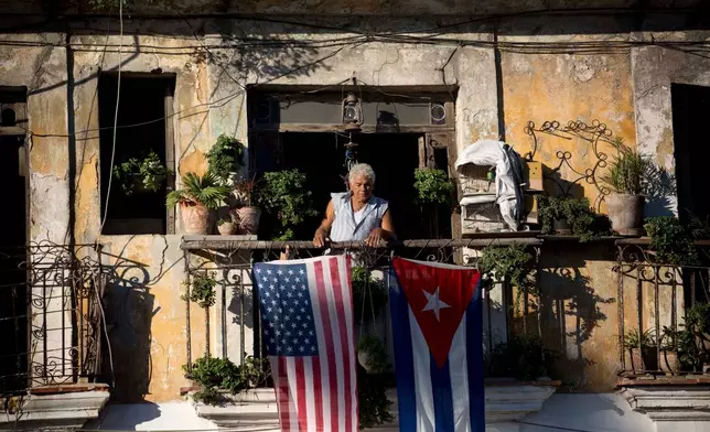 FILE - Javier Yanez stands on his balcony where he hung a U.S. and Cuban flag in Old Havana Cuba, Friday, Dec. 19, 2014. (AP Photo/Ramon Espinosa, File)