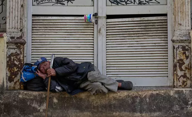 A man sleeps on a street in Havana, Tuesday, Feb. 24, 2026. (AP Photo/Ramon Espinosa)