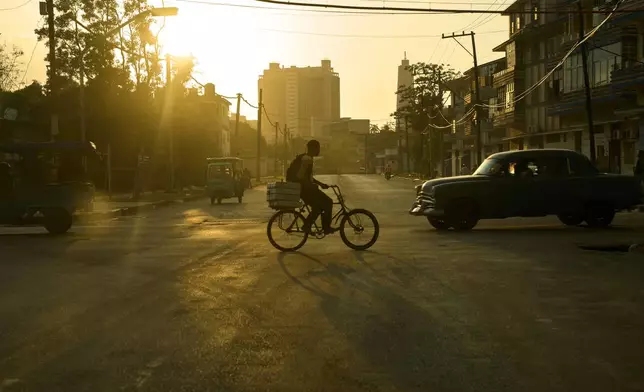 A man rides his bicycle at sunset in Havana, Wednesday, Feb. 18, 2026. (AP Photo/Ramon Espinosa)