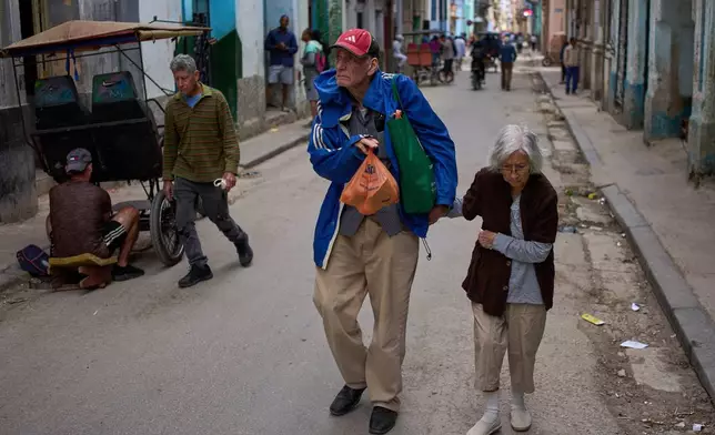 People walk down a street in Havana, Tuesday, Feb. 24, 2026. (AP Photo/Ramon Espinosa)