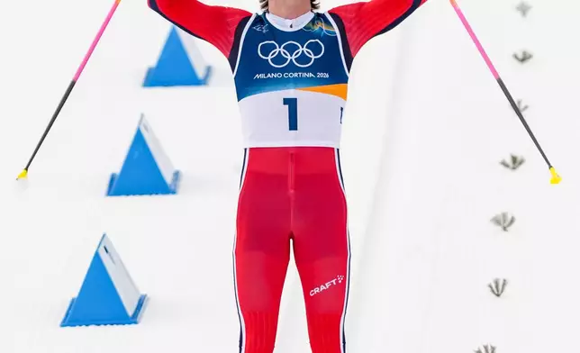 Johannes Hoesflot Klaebo, of Norway, crosses the finish line to win the gold medal during the cross country skiing men's 50km mass start Classic at the 2026 Winter Olympics, in Tesero, Italy, Saturday, Feb. 21, 2026. (AP Photo/Kirsty Wigglesworth)