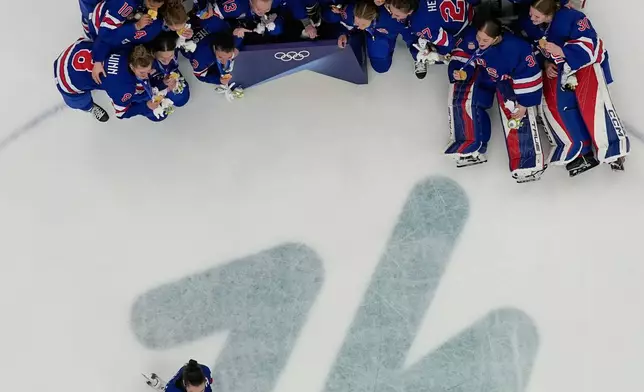 United States' Megan Keller (5) takes a photographer with the team after the United States beat Canada 2-1 in overtime in the women's ice hockey gold medal game at the 2026 Winter Olympics, in Milan, Italy, Thursday, Feb. 19, 2026. (AP Photo/David J. Phillip)