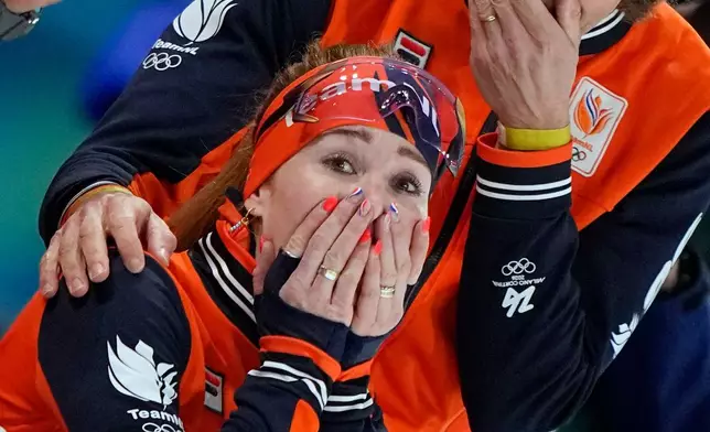 Antoinette Rijpma-de Jong of the Netherlands celebrates winning the gold medal with her coach Gerard van Velde, right, after the women's 1500 meters speedskating race at the 2026 Winter Olympics, in Milan, Italy, Friday, Feb. 20, 2026. (AP Photo/Ben Curtis)
