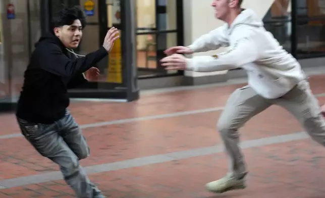 Plain clothed federal agents pursue a man through the lobby of the Hennepin County Government Center in Minneapolis before tackling and arresting him, on Tuesday, Feb. 10, 2026. (Anthony Souffle/Star Tribune via AP)