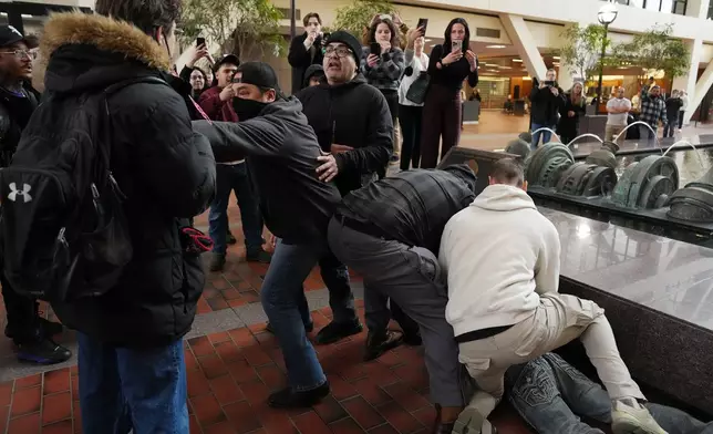 Plain clothed federal agents tackle and arrest a man after a short foot chase in the lobby of the Hennepin County Government Center in Minneapolis, on Tuesday, Feb. 10, 2026. (Anthony Souffle/Star Tribune via AP)