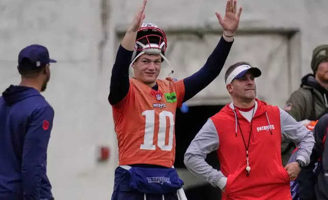 New England Patriots quarterback Drake Maye, left, signals after a field goal while standing with offensive coordinator Josh McDaniels during an NFL football availability, Thursday, Jan. 29, 2026, in Foxborough, Mass. (AP Photo/Charles Krupa)