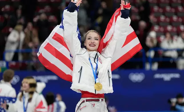 Team USA's Amber Glenn celebrates with her gold medal after the figure skating team event at the 2026 Winter Olympics, in Milan, Italy, Sunday, Feb. 8, 2026. (AP Photo/Ashley Landis)