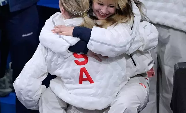 Alysa Liu hugs Amber Glenn after Team USA secured the gold medal in the figure skating team event at the 2026 Winter Olympics, in Milan, Italy, Sunday, Feb. 8, 2026. (AP Photo/Natacha Pisarenko)