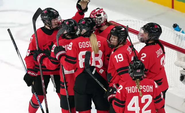 Team Canada players celebrate after their win over Switzerland in a women's ice hockey semifinal match at the 2026 Winter Olympics, in Milan, Italy, Monday, Feb. 16, 2026. (AP Photo/Carolyn Kaster)