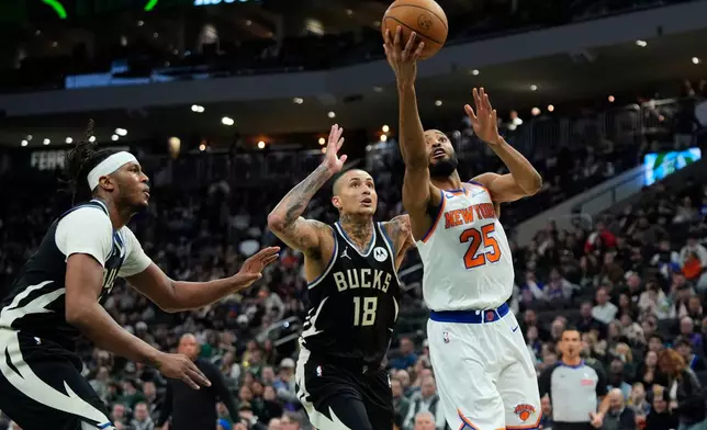 New York Knicks' Mikal Bridges (25) shoots against Milwaukee Bucks' Kyle Kuzma (18) during the second half of an NBA basketball game Friday, Feb. 27, 2026, in Milwaukee. (AP Photo/Aaron Gash)