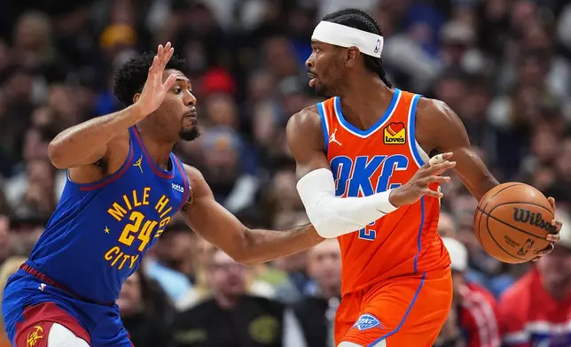 Oklahoma City Thunder guard Shai Gilgeous-Alexander, right, looks to pass the ball as Denver Nuggets guard Jalen Pickett defends in the first half of an NBA basketball game Sunday, Feb. 1, 2026, in Denver. (AP Photo/David Zalubowski)