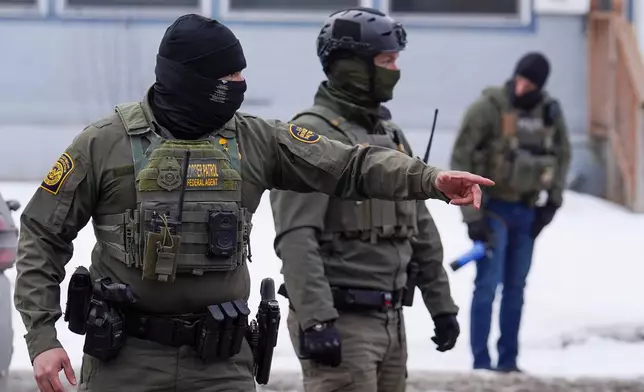 A United States Border Patrol agent gestures to a car while conducting immigration enforcement operations, Thursday, Feb. 5, 2026, in Minneapolis. (AP Photo/Ryan Murphy)