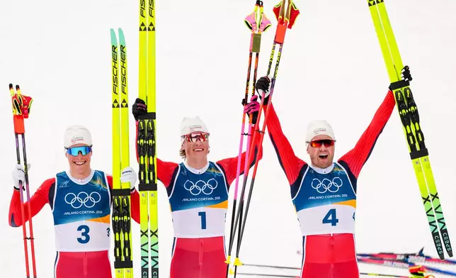 Silver medalist Martin Loewstroem Nyenget, gold medalist Johannes Hoesflot Klaebo and bronze medalist Emil Iversen, all three of Norway, pose after the cross country skiing men's 50km mass start Classic at the 2026 Winter Olympics, in Tesero, Italy, Saturday, Feb. 21, 2026. . (AP Photo/Kirsty Wigglesworth)