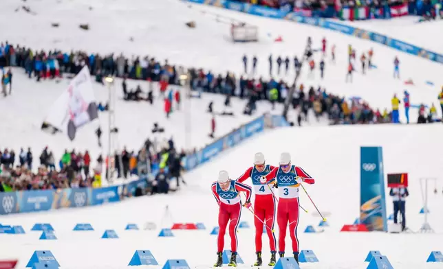 Johannes Hoesflot Klaebo, from left, Emil Iversen and Martin Loewstroem Nyenget, all three of Norway, compete in the cross country skiing men's 50km mass start Classic at the 2026 Winter Olympics, in Tesero, Italy, Saturday, Feb. 21, 2026. (AP Photo/Evgeniy Maloletka)