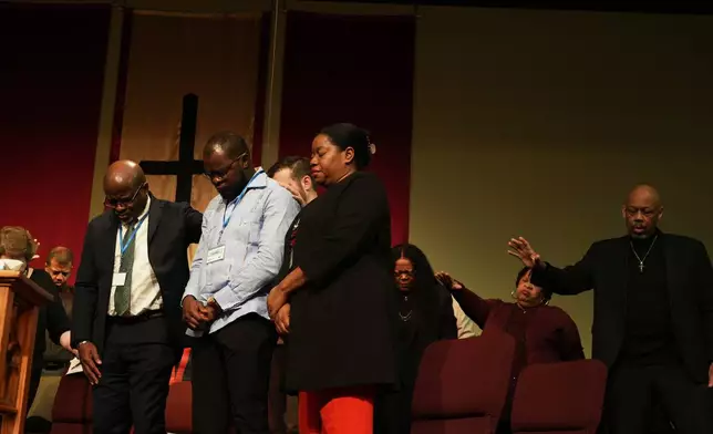 Faith leaders and Haitian community leaders pray at St. John Missionary Baptist Church in Springfield, Ohio, Monday, Feb. 2, 2026, during an event in support of Haitian migrants fearing the end of their Temporary Protected Status in the U.S. (AP Photo/Luis Andres Henao)