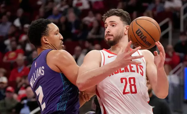 Houston Rockets center Alperen Sengun (28) tries to control the ball against Charlotte Hornets forward Grant Williams (2) during the first half of an NBA basketball game, Thursday, Feb. 5, 2026, in Houston. (AP Photo/ Karen Warren)